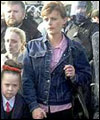 Catholic parents escort their children with RUC Officers in riot gear to the Holy Cross School in Belfast 