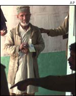 An Indian official points a voter in the direction of a polling booth 