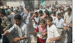 Crowd carrying the bodies of the victims.
