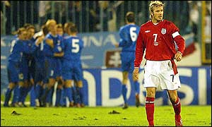 Slovakia players celebrate the opening goal while David Beckham trudges back to the centre-circle
