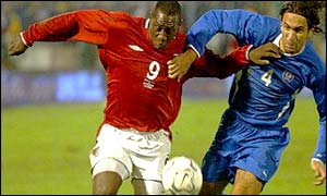 Emile Heskey is held back by Slovakia's Peter Hlinka 