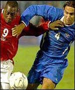 Emile Heskey is held back by Slovakia's Peter Hlinka 