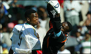 Patrick Mayo heads past Aime Kitenge