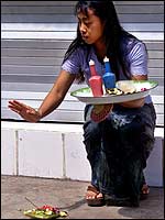 A Balinese woman makes a prayer offering near the site of a deadly bomb explosion 