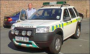 A doctor stands by his vehicle