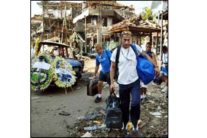 Tourists walk past the bombed nightclub (AP)
