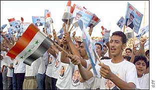 Iraqi youths wear t-shirts with President Saddam Hussein�s portrait and wave flags and portraits 