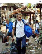 Tourists walk with their bags past the scene of the blast