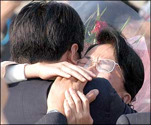Fukie Hamamoto (right) hugs one of her relatives (AP)