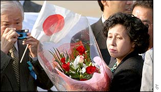 Hitomi Soga holds a bouquet of flowers given to her on arrival in Tokyo