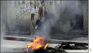 A man walks past a street fire on election day last week 