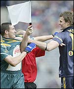 A linesman intervenes as Ireland's Ciaran McManus and Australia's Luke Darcy confront each other