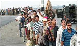 Palestinians queue to return to Gaza after a day's work in Israel