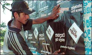 A campaigner hangs posters in last years elections
