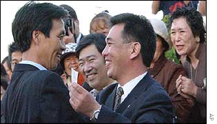 Kaoru Hasuike (left) is greeted by one of his high school classmates