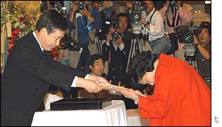 Hitomi Soga receives her diploma from the Sado High School headmaster 