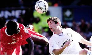 Harry Kewell jumps for the ball with Djimi Traore