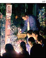 Photos of victims are pinned to a cross at the Australian consulate in Denpasar