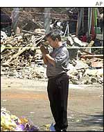 A Balinese man prays amid the ruins of the Sari Club
