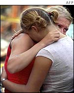Two Australian women comfort each other at the site of the bomb blast