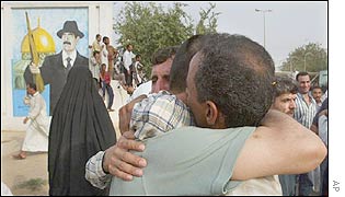 Iraqi prisoner and his relative hug each other