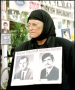 Greek-Cypriot woman with pictures of her missing relatives