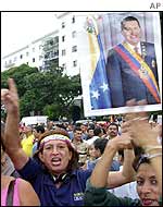 Chavez supporter holding a placard of the Venezuelan president at a rally in his support