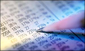 Pencil pointing to share prices in a newspaper 