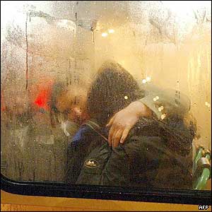 A released hostage (black jacket) is comforted by police inside a police bus 