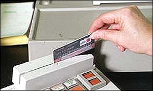 A hand swiping a credit card