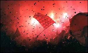Fans light flares at a football match