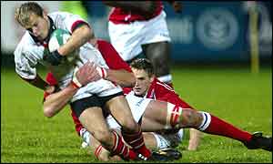 Ulster winger Scott Young is tackled by Llanelli lock Luke Gross