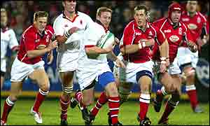 Llanelli's Ireland scrum-half Guy Easterby about to tackle Ulster centre Shane Stewart
