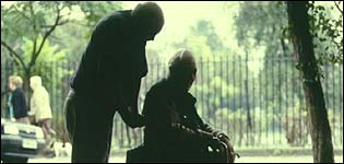 Elderly carer with man in wheelchair