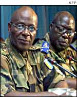 General Doue is seated with aides at the opening of the Ecowas meeting