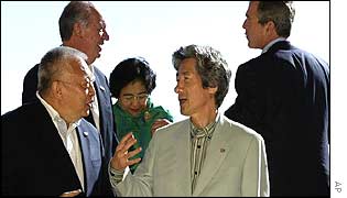 Hong Kong leader Tung Chee-Hua (l) talks with Japan's PM Junichiro Koizumi, in front of the Chilean, Indonesian and US presidents 