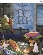 A woman lays flowers outside the Palace of Culture theatre