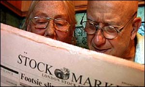 An elderly couple reading the paper