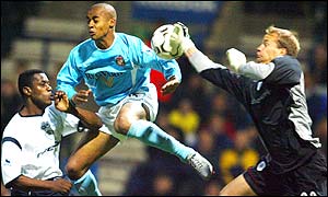 Jussi Jaaskelainen comes for a cross under pressure from David Bellion