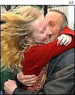 A father embraces his daughter, a former hostage, on her release from hospital on Monday