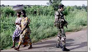 Women pass a French soldier near Bouake