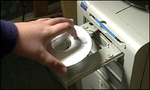Hand putting CD into computer drive