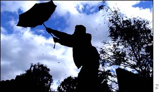 Man wrestles with umbrella during high winds