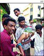 Residents of the Muslim community carry an injured man in Colombo