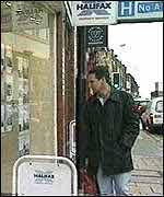 A man looking in the window of an estate agent