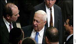 Ariel Sharon (centre) talks to coalition members after budget vote