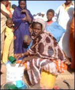 Scooping out water at a feeding centre 