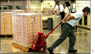A man dragging a stack of 10,000-yen notes in a vault