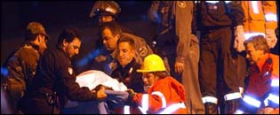 Rescuers remove the body of a child from the wreckage of the school