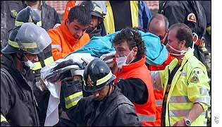 Rescuers remove a child's body from the ruins